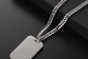 Macro shot of silver rectangular military dog tag pendant with heavy link chain