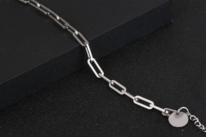 Dettaglio macro del bracciale a maglie rettangolari d'argento con ciondolo tondo liscio