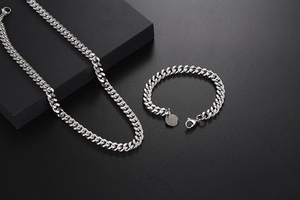 Détail de l'ensemble collier et bracelet à maille gourmette en argent poli sur support