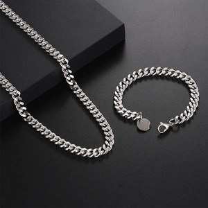 Ensemble collier et bracelet à maille gourmette argentée pour homme sur support moderne