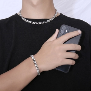 Ensemble collier et bracelet à mailles gourmette argentées porté par un homme