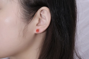 Detailed view of mini chili fruit stud earring featuring red enamel and gold finish