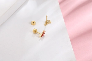 Detailed shot of gold-plated stainless steel screw-back earrings with red enamel