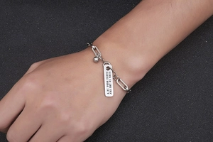 Makroaufnahme von Silber-Titanstahl-Büroklammer-Armband mit graviertem Rechteck-Tag
