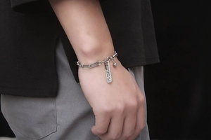 Detail eines silbernen Barrenarmbands mit Gravur Every Body Is A Star und Anhänger