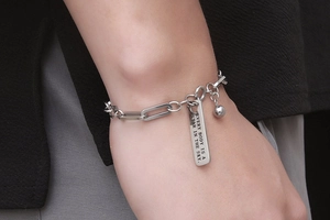 Detail eines silbernen Edelstahl-Armbands mit gravierter rechteckiger Stern-Plakette