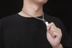 Primer plano del collar de cadena de acero titanio con cierre OT y placa grabada