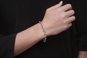 Close-up of industrial style silver stainless steel rolo chain bracelet on wrist