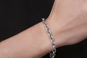 Close-up of a silver stainless steel chunky chain link bracelet worn on a male wrist