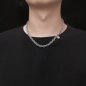 Men's silver steel cable chain necklace with small circular tag on black background
