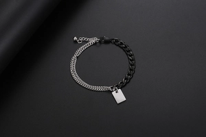 Detail eines gemischten silber-schwarzen Panzerarmbands mit rechteckigem Metallanhänger