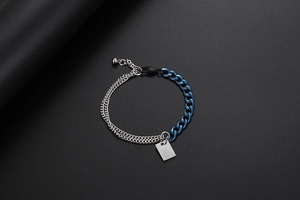 Detail eines zweifarbigen Panzerkettenarmbands mit rechteckigem Anhänger und Verschluss