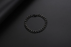 Detail eines minimalistischen schwarzen Panzerarmbands mit flachen Gliedern