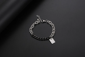 Dettaglio del bracciale a catena bicolore argento e nero con targhetta lucida