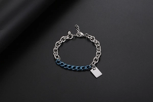 Dettaglio macro del bracciale a catena bicolore blu e argento con targhetta rettangolare