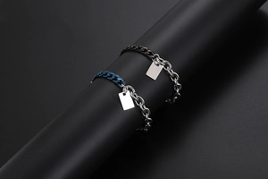 Dettaglio dei bracciali a catena cubana mista argento, blu e nero con pendenti