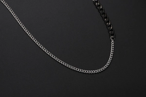 Detail einer zweifarbigen Industrial Cuban Gliederkette mit silber-schwarzem Kontrast