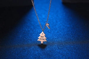 Detail von roségoldenen Weihnachtsbaum- und Zuckerstangen-Anhängern an einer Gliederkette