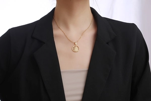 Nahaufnahme einer goldenen Weihnachtsbaum-Halskette getragen auf einem schwarzen Blazer