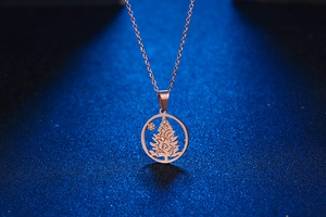 Detailaufnahme der roségoldenen Weihnachtsbaum-Halskette mit Kristallen und feiner Kette
