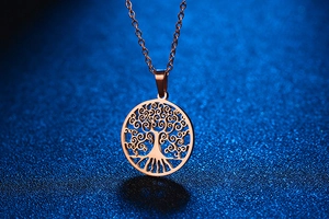 Detailweergave van de levensboom hanger in roségoud op een fijne ketting tegen blauw