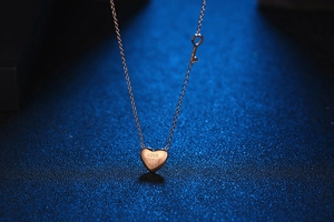 Detail of rose gold heart pendant engraved with LOVE FOREVER 520 and key charm