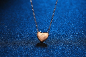 Macro shot of rose gold heart pendant featuring Love Forever 520 engraving on cross chain