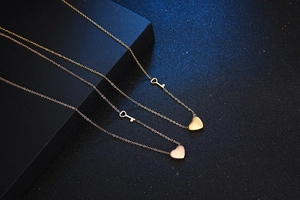 Macro detail of gold and rose gold heart lock pendants with key charms on fine chains