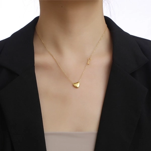 Titanium steel heart lock necklace with key charm worn on elegant black blazer