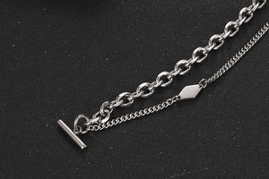 Detail eines silbernen doppellagigen Kettenarmbands mit OT-Verschluss und Rautenanhänger