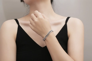 Close-up of minimalist silver Cuban chain bracelet on wrist with polished metal finish