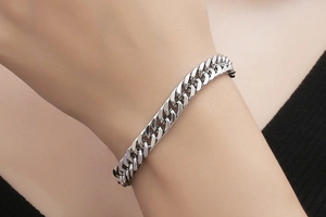 Close-up of minimalist silver stainless steel Cuban link bracelet worn on a wrist