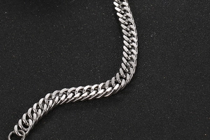 Macro shot of silver titanium steel Cuban link bracelet with a sleek S-curve detail
