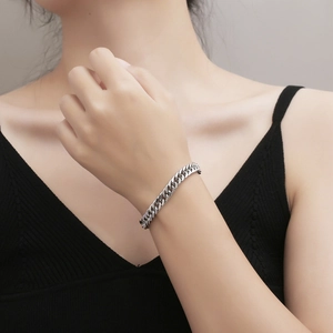 Minimalist silver Cuban curb chain bracelet shown on wrist for fashion accessory style