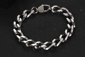 Dettaglio del bracciale in acciaio al titanio con maglie geometriche e chiusura a moschettone