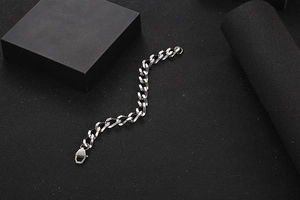 Dettaglio macro di un bracciale a catena in acciaio al titanio argento con chiusura a moschettone