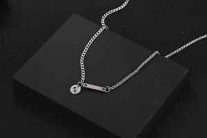 Detalle del colgante Sagitario y barra rectangular en cadena plateada de estilo hip hop