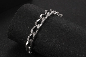 Dettaglio ravvicinato del bracciale a catena in acciaio inossidabile lucido su nero