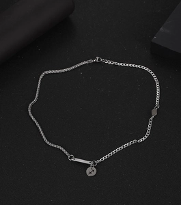 Detalle del colgante Sagitario de plata y eslabones geométricos sobre fondo negro mate