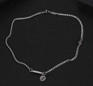 Detalle de cadena de eslabones de acero plateado con colgante del signo Sagitario
