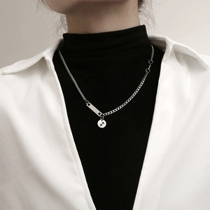 Collar unisex de acero de titanio con colgante de Sagitario sobre un jersey de punto negro