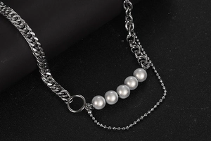 Detalle de cadena de eslabones plateada y perlas grises para un collar unisex moderno