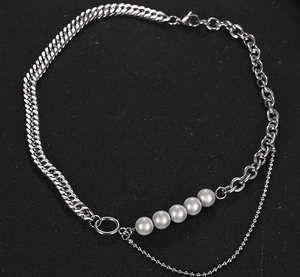 Detalle del collar industrial de titanio con perlas plateadas y cadenas mixtas
