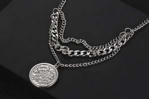 Macro shot of silver layered chains featuring an embossed elephant pendant for men