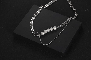Detalle del collar de acero de titanio con cadenas múltiples y cinco perlas blancas finas