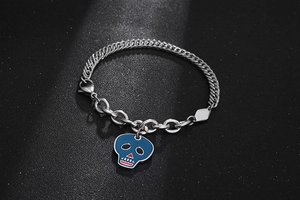 Dettaglio del bracciale a teschio in titanio con ciondolo in smalto e catena a maglie miste