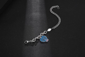 Dettaglio del bracciale punk con doppia catena e ciondolo a forma di teschio blu smaltato