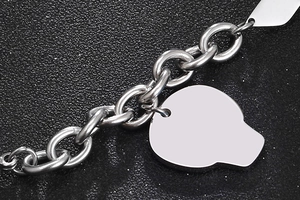 Dettaglio macro del bracciale a catena in acciaio al titanio con ciondolo a teschio