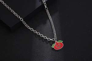 Detail of a punk pumpkin pendant on an asymmetrical silver stainless steel chain link