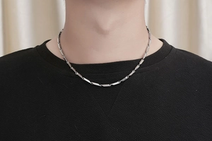Detail of masculine silver stainless steel necklace with geometric column links on neck
